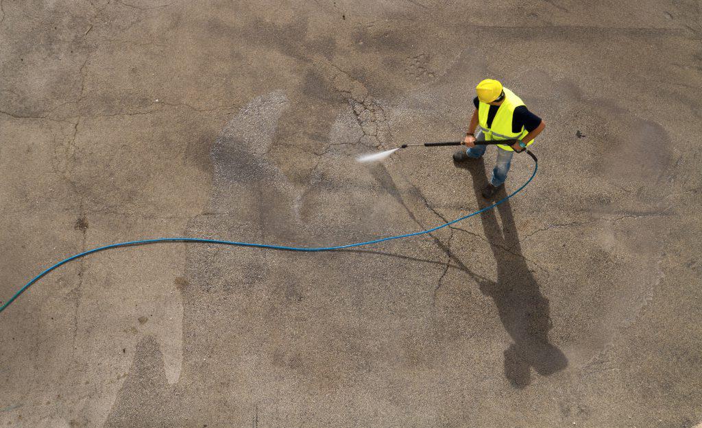 一名男子使用电动清洗机清洗工业地板